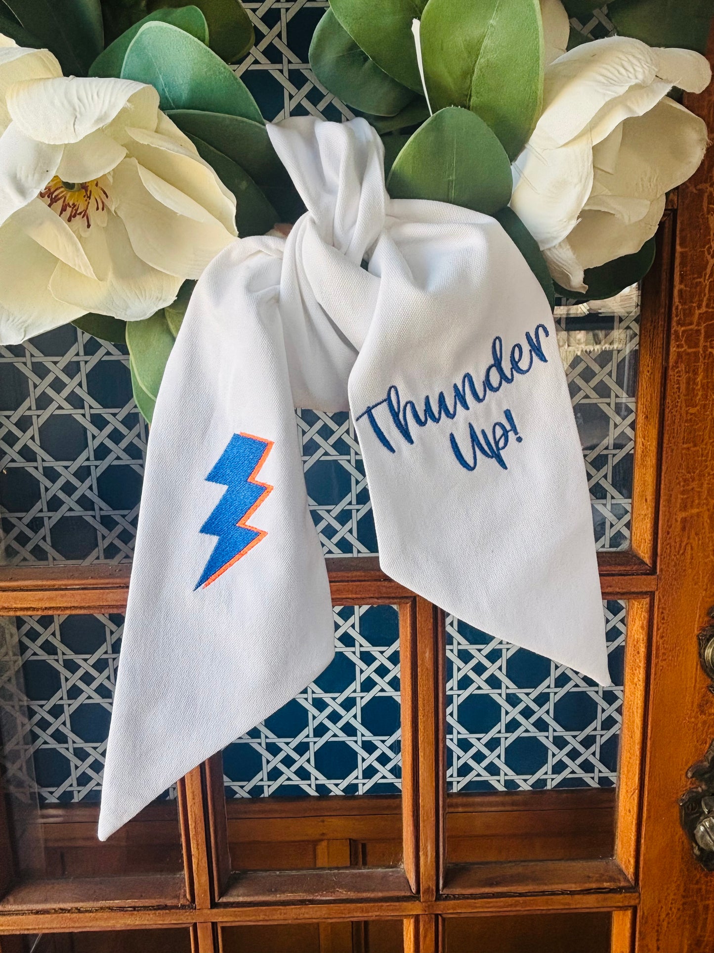 OKC Thunder wreath sash styled on front door wreath with white bow, blue lightning bolt embroidery, and “Thunder Up” lettering