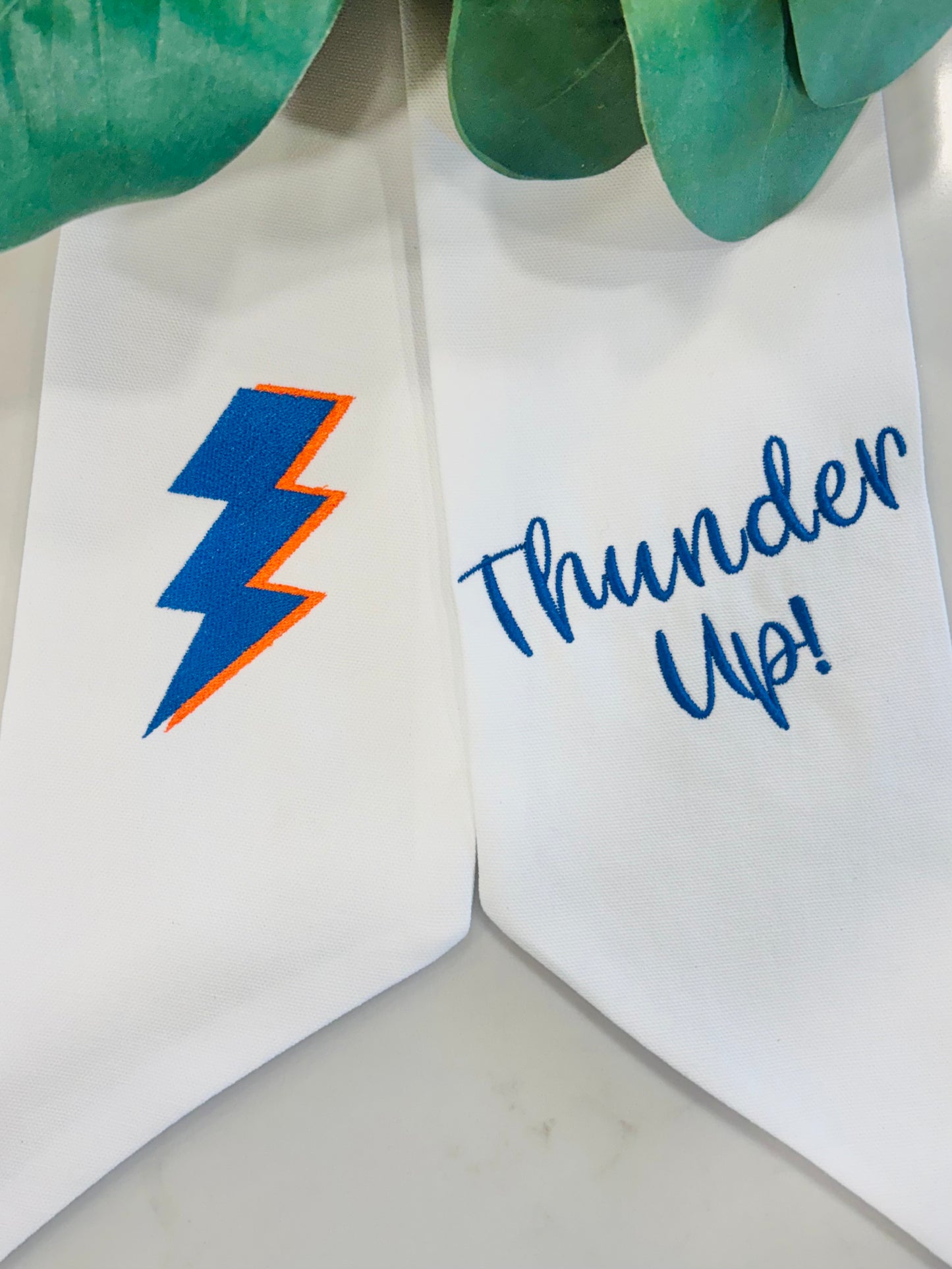 OKC Thunder wreath sash embroidery detail with blue lightning bolt and “Thunder Up” text on white fabric
