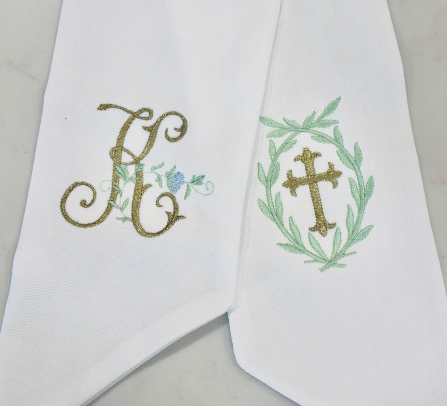 Personalized white wreath sashes with embroidered monogram and cross designs